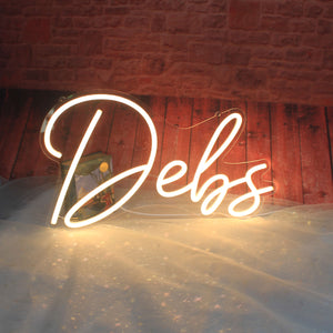 The image shows a custom LED neon sign spelling out the name "Debs." These types of signs are popular for various uses, including home decor, retail shop props and social events.