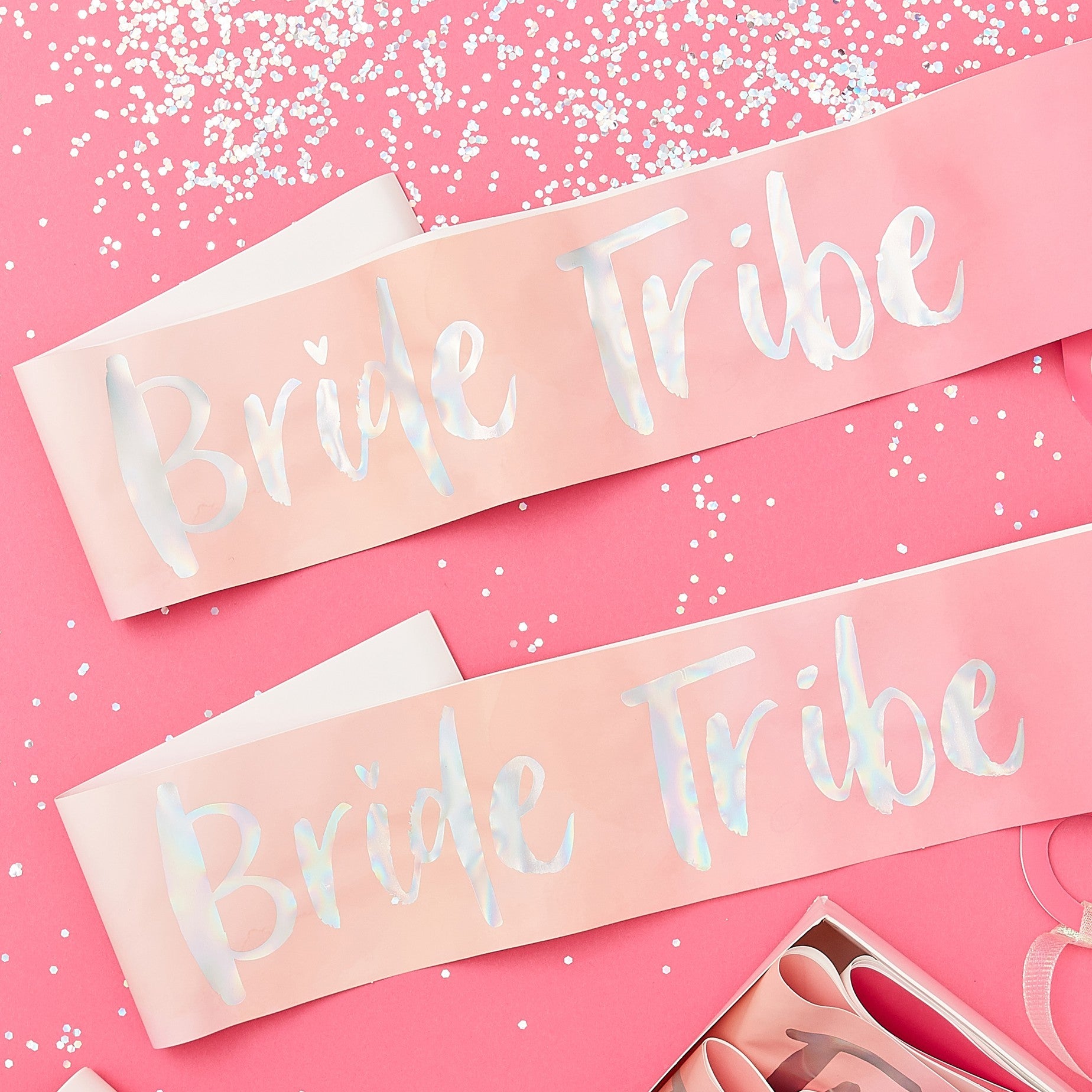 Pink Sash with silver iridescent text which reads Bride Tribe, add a perfect pop of colour and sparkle to your hen party with these sashes for the attendees. there is a matching sash of course for the Bride to be