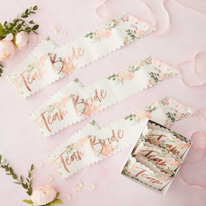 Pack of 6 Floral sashes, with "Team Bride" in rose gold foiling , floral design and scalloped edges ties with a pink ribbon. Sash is made from paper and would suit floral, rose gold or botanical theme bridal shower or hen party decor